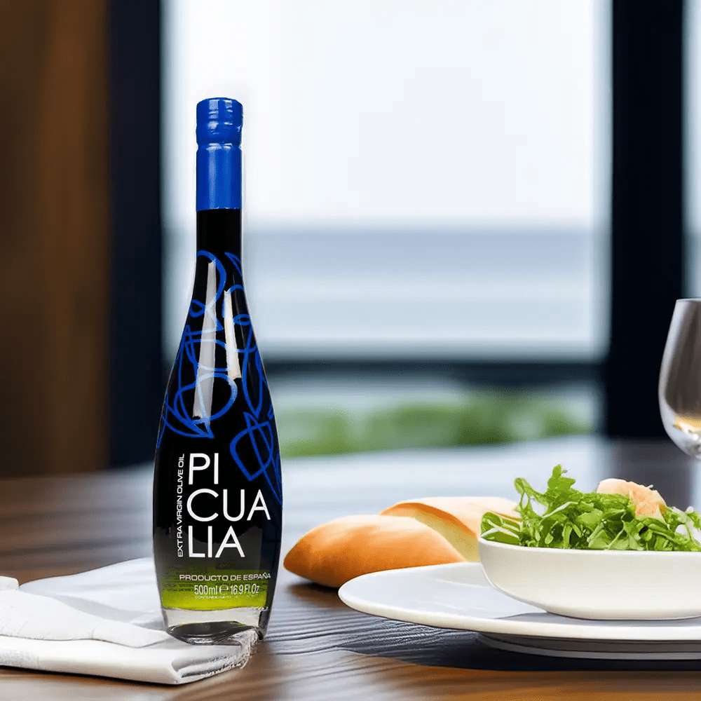 Botella de aceite de oliva virgen extra Picualia Reserva 500ml en una mesa mediterránea