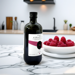 Pago de Peñarrubia Aceite de Oliva Virgen Extra Ecológico Arbequina 500ml en una cocina moderna de mármol con un plato de frambuesas